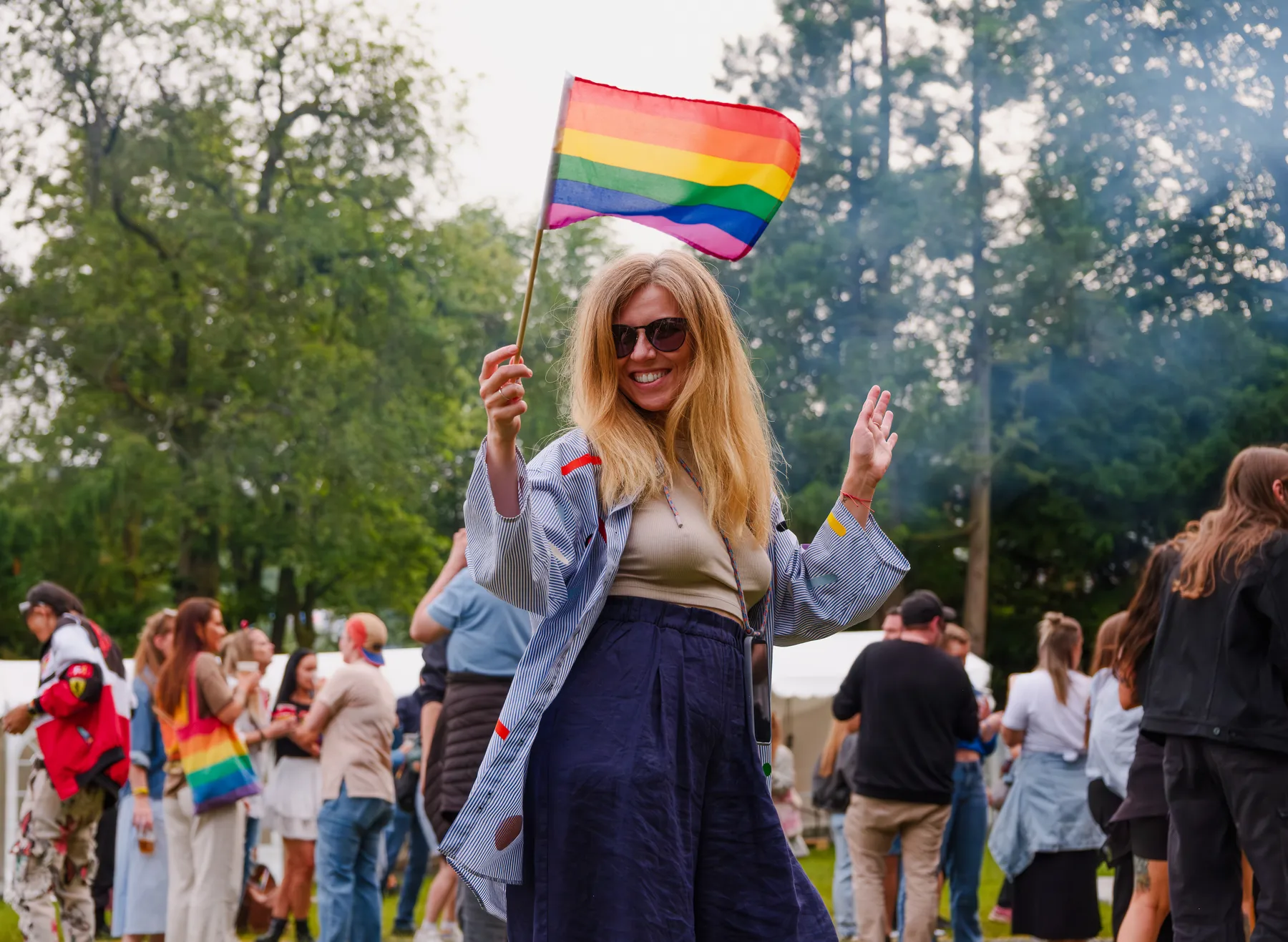 Glad festivaldeltaker med regnbueflagg i Pride Park